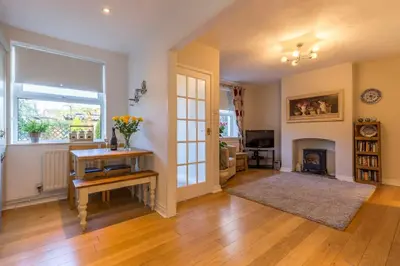 a living room with a table and a fireplace at Shrimpers Cottage in Lytham St Annes