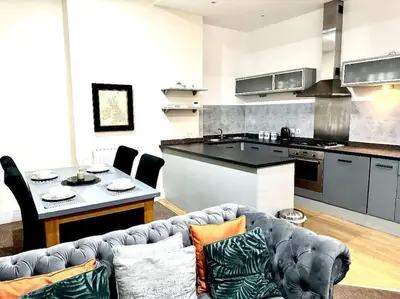 a living room with a couch and a kitchen at Luxury City Apartment 2 Bedroom Suite in Preston
