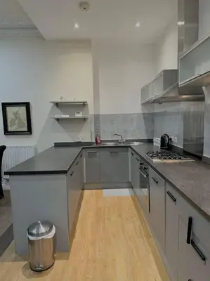 a kitchen with stainless steel appliances and a wooden floor at Luxury City Apartment 2 Bedroom Suite in Preston