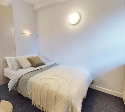 a bedroom with a bed in a white room at Ormskirk lets in Ormskirk