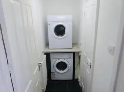 a laundry room with a washer and a washing machine at Ormskirk lets in Ormskirk