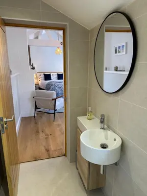 a bathroom with a sink and a mirror and a bed at The Old Wash House in Lytham St Annes