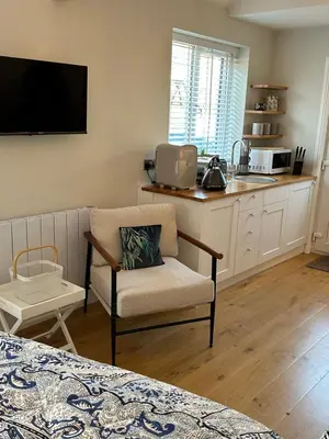 a living room with a chair and a kitchen at The Old Wash House in Lytham St Annes