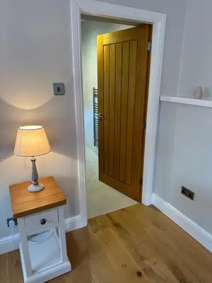 a room with a door and a table with a lamp at The Old Wash House in Lytham St Annes
