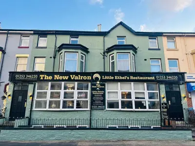a green building with a new valuation sign in front of it at The New Valeron Hotel in Blackpool