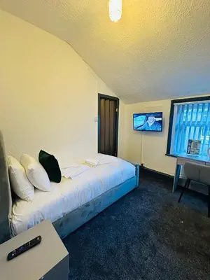 a hotel room with a bed and a television at The New Valeron Hotel in Blackpool