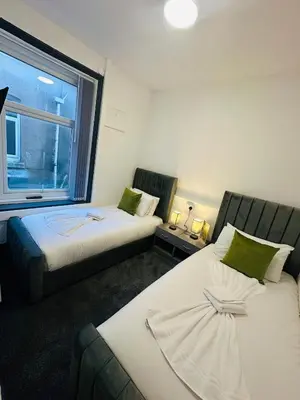 two beds in a room with a window at The New Valeron Hotel in Blackpool