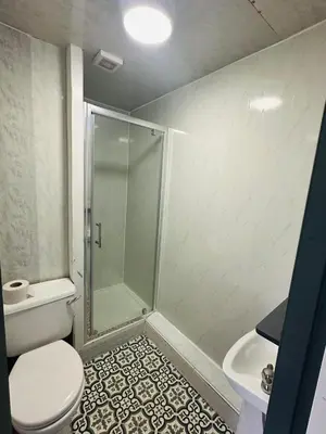 a bathroom with a shower and a toilet and a sink at The New Valeron Hotel in Blackpool
