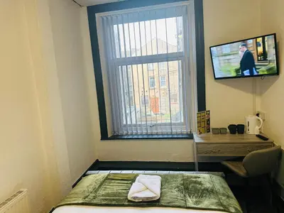 a small room with a bed and a window at The New Valeron Hotel in Blackpool