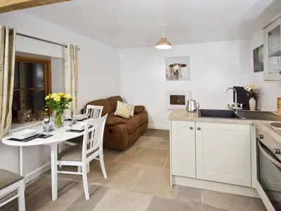a kitchen and living room with a table and a couch at The Stable - 30562 in Whalley