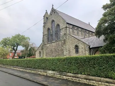 an old brick church with a hedge in front of it at Cheerful 2 bedroom town house in Lancashire in Chorley