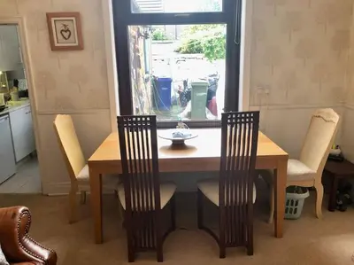 a dining room table with chairs and a window at Cheerful 2 bedroom town house in Lancashire in Chorley