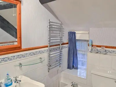 a bathroom with a sink and a toilet and a mirror at Tom's Cottage in Dalton in Furness