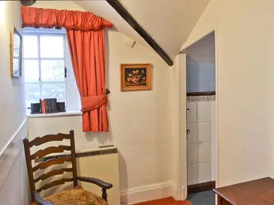 a dining room with a chair and a window at Tom's Cottage in Dalton in Furness