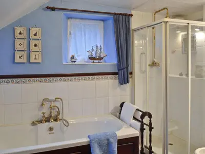 a bathroom with a tub and a shower at Tom's Cottage in Dalton in Furness