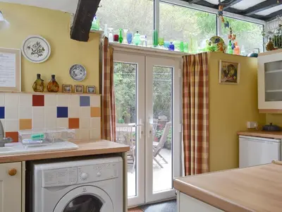 a kitchen with a washer and dryer in a kitchen at Tom's Cottage in Dalton in Furness
