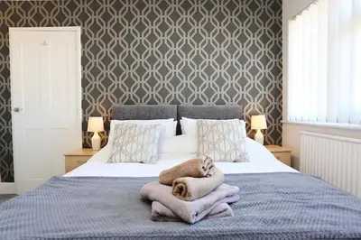 a bedroom with a large bed with blankets and pillows at Fabulous beachfront 3 bed house with parking in Cleveleys