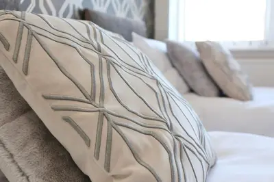 a pillow on a bed with pillows on it at Fabulous beachfront 3 bed house with parking in Cleveleys