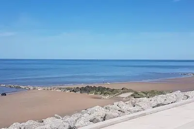 a view of a beach with rocks and the ocean at Fabulous beachfront 3 bed house with parking in Cleveleys