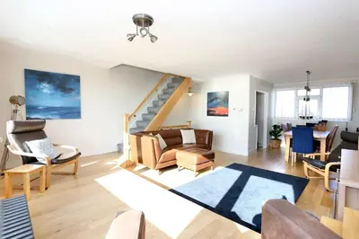 a living room filled with furniture and a staircase at Fabulous beachfront 3 bed house with parking in Cleveleys
