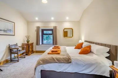 a bedroom with a large white bed with orange pillows at 2 Bed in Oakenclough oc-m30216 in Scorton