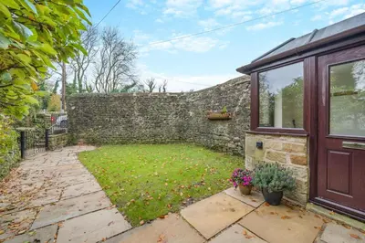 a garden with a stone wall and a door at 2 Bed in Oakenclough oc-m30216 in Scorton