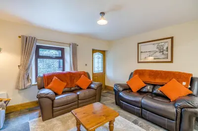 a living room with two leather couches and a table at 2 Bed in Oakenclough oc-m30216 in Scorton