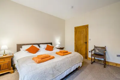 a bedroom with a bed with orange pillows on it at 2 Bed in Oakenclough oc-m30216 in Scorton