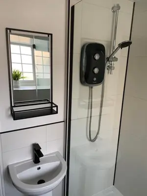a bathroom with a shower and a sink and a mirror at Willow View, Cartmel in Cartmel