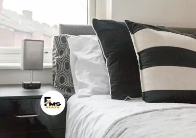 a bed with black and white pillows next to a window at Large 6 Bed House, Long Term Stay Savings, Contractors, Professionals, Big Groups, Free Parking! in Liverpool