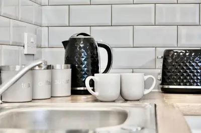 a kitchen counter with cups and a sink at Large 6 Bed House, Long Term Stay Savings, Contractors, Professionals, Big Groups, Free Parking! in Liverpool