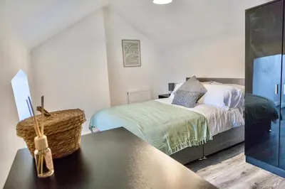 a bedroom with a bed and a table at Large 6 Bed House, Long Term Stay Savings, Contractors, Professionals, Big Groups, Free Parking! in Liverpool
