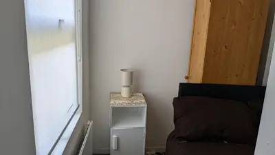 a small table with a vase on it next to a bed at Best homestay Close To City Centre in Liverpool