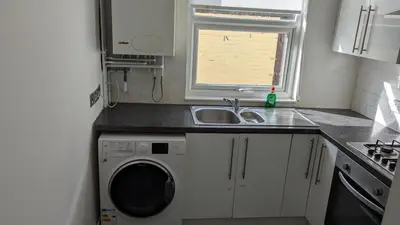 a kitchen with a sink and a washing machine at Best homestay Close To City Centre in Liverpool