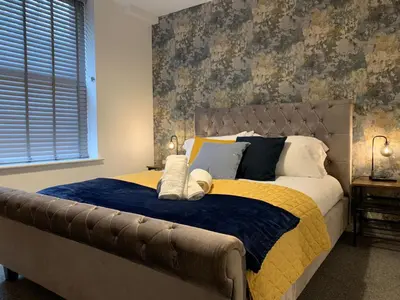a bedroom with a large bed with a blue and yellow blanket at Bright 1 bed Apartment with Parking in Preston