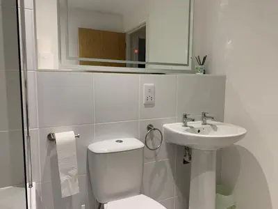 a white bathroom with a toilet and a sink at Bright 1 bed Apartment with Parking in Preston