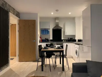 a kitchen and dining room with a table and chairs at Bright 1 bed Apartment with Parking in Preston