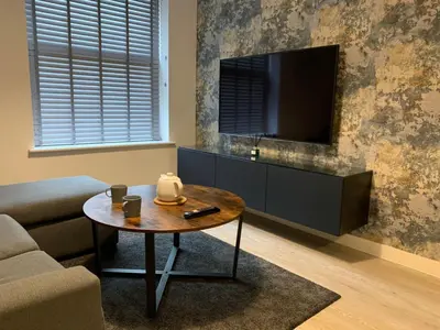 a living room with a coffee table and a flat screen tv at Bright 1 bed Apartment with Parking in Preston