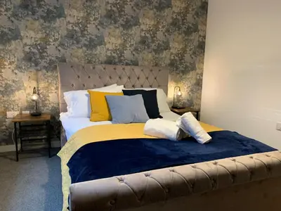 a bedroom with a large bed with yellow and blue sheets at Bright 1 bed Apartment with Parking in Preston