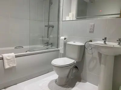 a white bathroom with a toilet and a sink at Bright 1 bed Apartment with Parking in Preston