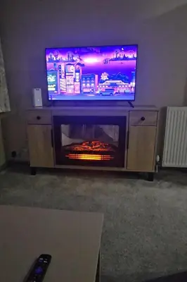 a tv sitting on top of a entertainment center with a fireplace at Escape in Carnforth Lodge - Sleeps 6 in Carnforth
