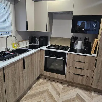 a kitchen with wooden cabinets and a stove top oven at Escape in Carnforth Lodge - Sleeps 6 in Carnforth