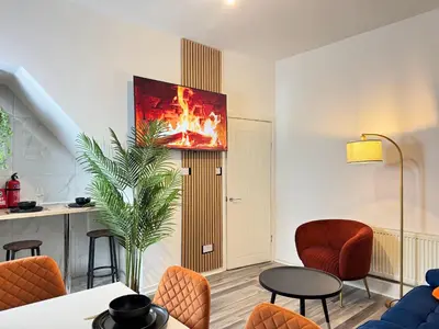 a living room with a fire painting on the wall at TV Every Bedroom 4 Bed 2 Bath Free Parking in Liverpool