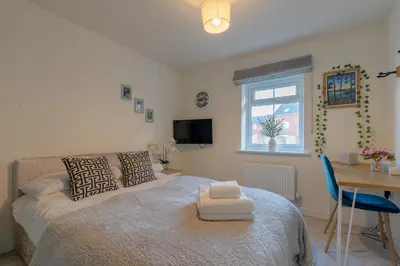 a bedroom with a bed and a desk and a window at Foxglove Haven- 3-Bed Detached - Garden - Drive in Longridge