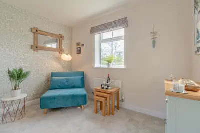 a living room with a blue chair and a table at Foxglove Haven- 3-Bed Detached - Garden - Drive in Longridge