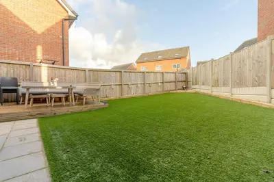 a patio with a table and a green lawn at Foxglove Haven- 3-Bed Detached - Garden - Drive in Longridge