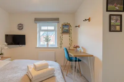 a bedroom with a bed and a desk and a window at Foxglove Haven- 3-Bed Detached - Garden - Drive in Longridge