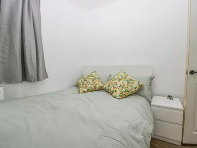 a bedroom with a bed with two pillows on it at Cosy Logs Cottage in Grange Over Sands