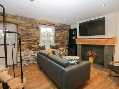 a living room with a couch and a fireplace at Cosy Logs Cottage in Grange Over Sands