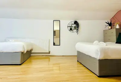 a room with two beds and a mirror on the wall at Specious Liverpool Central Apartment in Liverpool